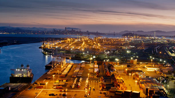 オークランド港と夕暮れ時のサンフランシスコのスカイラインの空撮 - port of oakland ストックフォトと画像