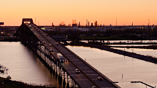 Aerial shot of Calcasieu River Bridge carrying Interstate 10 between Westlake and Lake Charles in Calcasieu Parish, Louisiana at sunset. On the opposite bank is a neighborhood next to oil refineries.
 
Authorization was obtained from the FAA for this operation in restricted airspace.
