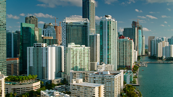 Aerial shot of skyscrapers in Brickell, Miami on a sunny spring morning with fluffy white clouds in a blue sky from over Biscayne Bay.