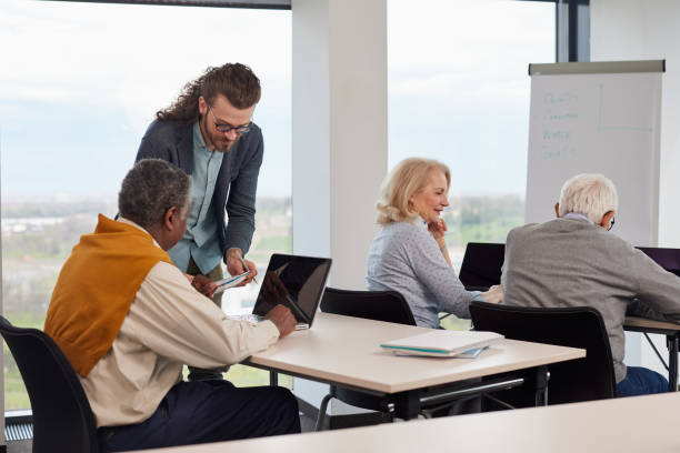 istock A multicultural group of elderly students discusses an assignment with their young educator in the classroom. 1407765747
