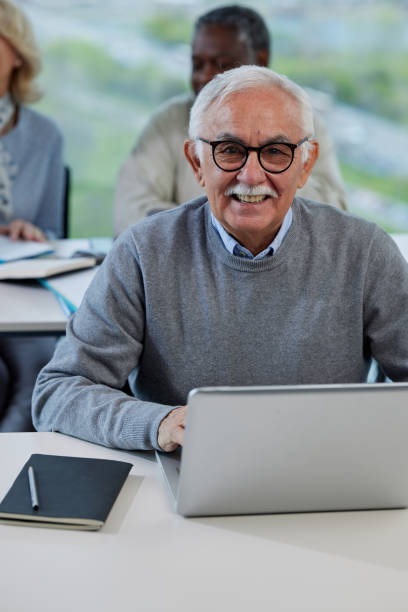 istock A senior man is smiling while having a retraining class with a multicultural group of senior people in the classroom. 1407765851