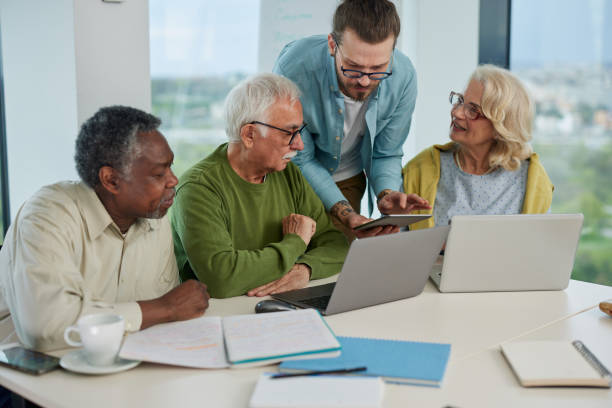 istock Young hipster educator teaching group of senior multiracial people using technology and the internet in the classroom. 1407766693