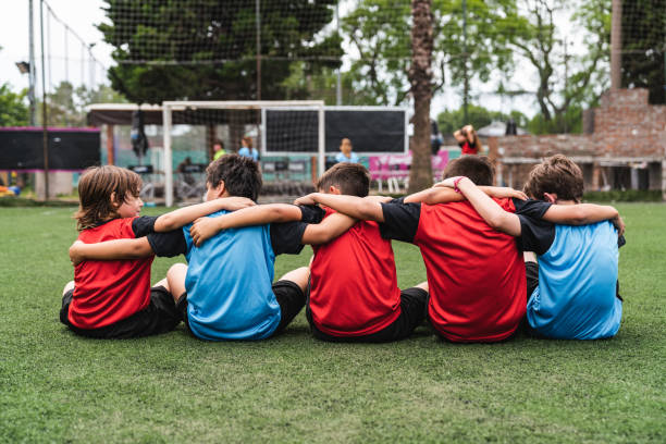 istock Boys sitting arm around on soccer field 1407767834