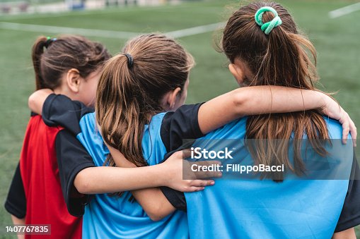 istock Three girls supporting each other while playing soccer 1407767835