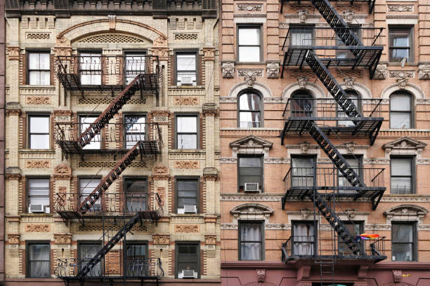 Façade d’un immeuble d’appartements à l’ancienne de Manhattan avec sculpture décorative en pierre ornée et échelles d’évacuation d’incendie extérieures - Photo