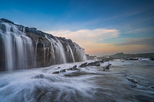 One of the areas in Indonesia that is rich in coastal tourism is Banten. One of the interesting locations to visit is the Karang Taraje Beach, Banten. Karang Taraje Beach is located about 38 kilometers from Malingping, precisely in Sawarna Village, Bayah District, Lebak Regency, Banten. Karang Taraje Beach is still next door to Sawarna Beach which is more widely known. But in terms of beauty, Karang Taraje Beach is not inferior to Sawarna Beach. Karang Taraje has a beach contour that is different from other beaches. Here, almost all sides of the beach are covered with rocks of various sizes. The coral on the left side of the beach even resembles a broad terrace and slightly steps like stairs. Therefore, the people named it Karang Taraje, which in Sundanese Taraje means stairs. https://ksmtour.com/informasi/tempat-wisata/banten/pantai-karang-taraje-dengan-tangga-karang-yang-unik-di-banten.html)