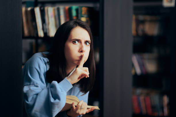 donna sconvolta che fa silenzio shh firma in una biblioteca - professor library librarian university foto e immagini stock