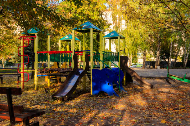 Colorful playground equipment for children in public park at autumn stock photo