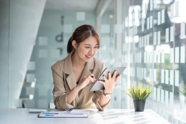 Portrait of young Asian business woman using digital tablet in the office. stock photo
