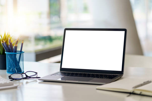 istock Laptop computer with blank white screen on table in the office. mock up. 1407787251