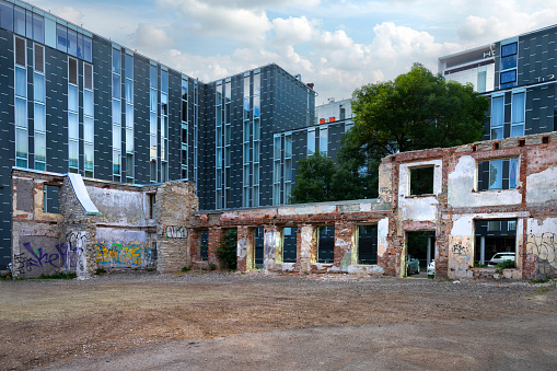 Tallinn, Estonia. July 2022.  view of an old dilapidated building in front of a modern building in the city center
