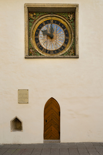 Tallinn, Estonia. July 2022.  The old wooden clock on the esternal wall of the  Holy Spirit Church in the city center