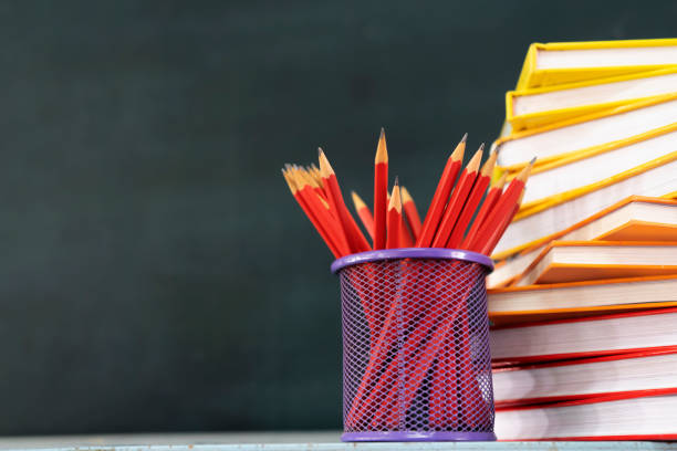 Back to the school background with a book, a red pencil box on the blackboard, an empty space can put text, advertising material.