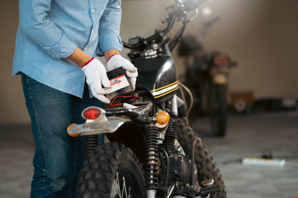 istock Choseup man mechanic in garage or workshop inspecting classic motorcycle during the maintenance and checks battery. 1407793055