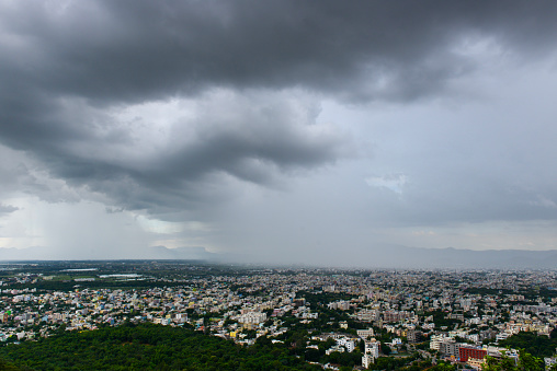 Rain filled monsoon clouds over a town in the south of India