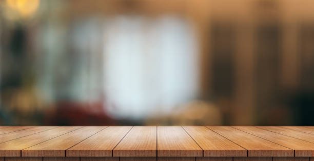 istock Empty wooden table top with lights bokeh on blur restaurant background. 1407797740