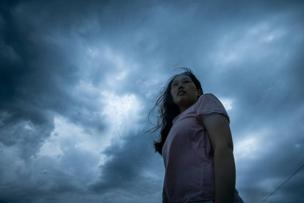 istock Women looking up storm cloud 1407807899