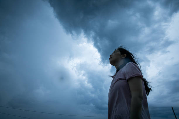 Women looking up storm cloud stock photo