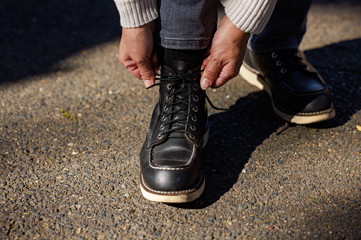 Woman tying her shoelace in the morning sun.