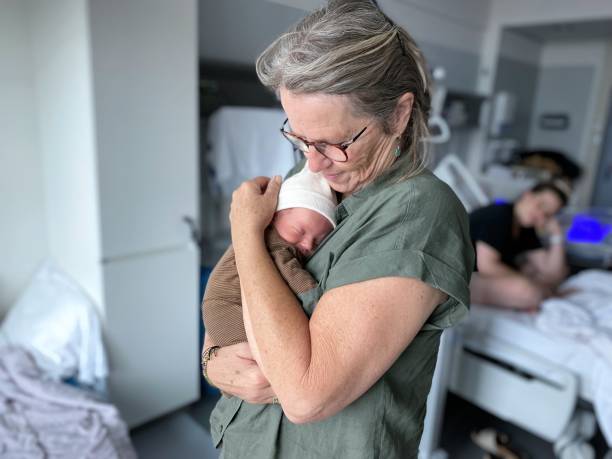 nonna che tiene in braccio un nipote appena nato - baby grandparent newborn grandmother foto e immagini stock