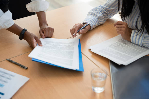 Shot of documents and female hands signing contract stock photo
