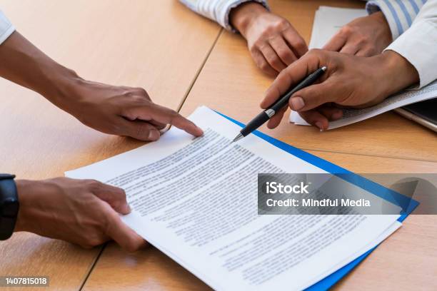 Closeup Shot Of Hands Holding And Pointing With A Pen At Documents Stock Photo - Download Image Now