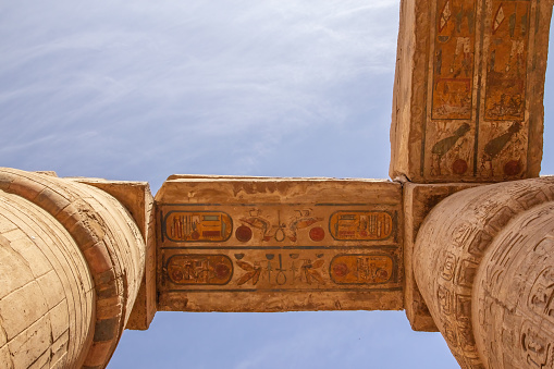 Columns with color hieroglyphs in Karnak temple. Blue sky in the background. Egypt.