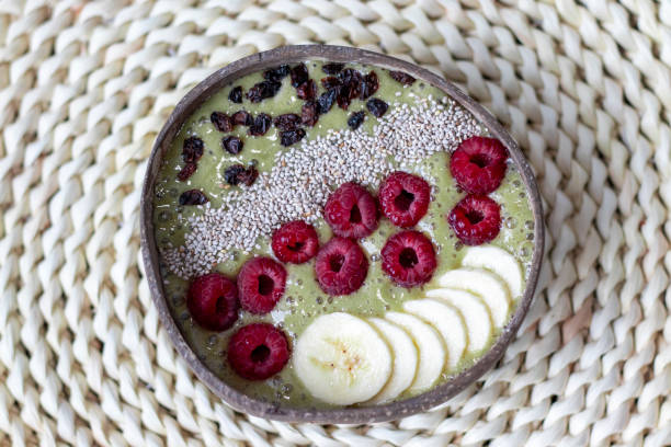 Colorful healthy food. Vegan Fruit Breakfast. Green Bowl with banana, raspberry, white chia seeds and barberry.