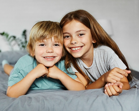 The little sister plays with her older brother at home. Life style. Activities for children at home.
