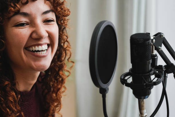 istock Young Latin host streaming live podcast on social media with microphone at home studio - Focus on face 1407824780
