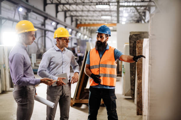 istock Engineers in factory hall, performing quality control. Manufacturing occupation in modern industrial hall, with automated process and robots. Metal processing industry and warehouse. 1407825027