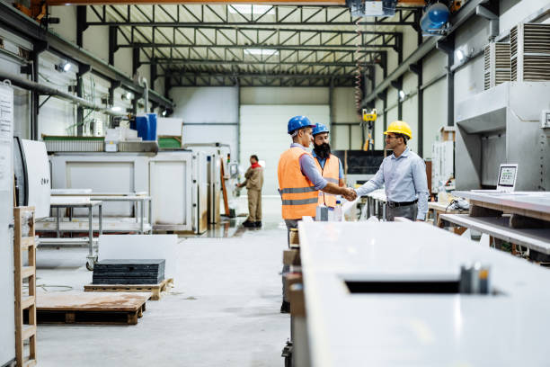 istock Engineers in factory hall, performing quality control. Manufacturing occupation in modern industrial hall, with automated process and robots. Metal processing industry and warehouse. 1407825067