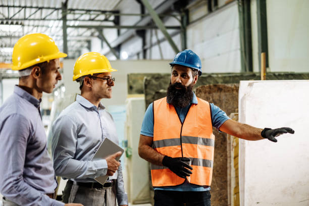 istock Engineers in factory hall, performing quality control. Manufacturing occupation in modern industrial hall, with automated process and robots. Metal processing industry and warehouse. 1407825168