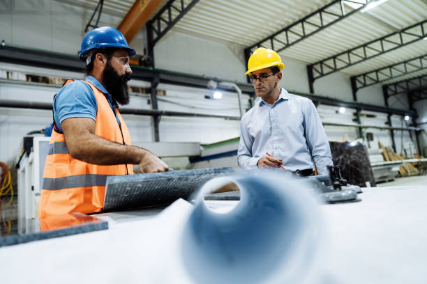 istock Engineers in factory hall, performing quality control. Manufacturing occupation in modern industrial hall, with automated process and robots. Metal processing industry and warehouse. 1407825860