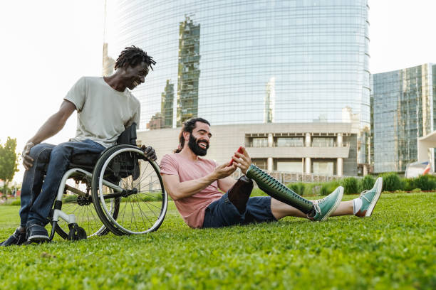 istock Happy diverse friends with physical disability having fun using mobile phone outdoor - Focus on leg prosthesis 1407826230