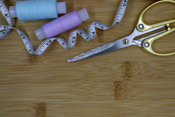 istock Set of sewing accessories on a wooden background. Fabric, threads, centimeter and scissors. 1407827459