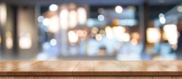 istock Empty wooden table with bokeh light effect and blur restaurant background. 1407829188