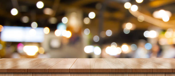 istock Empty wooden table with bokeh light effect and blur restaurant background. 1407829196