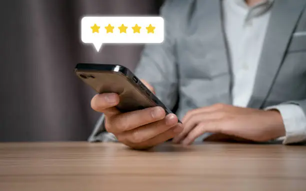 Photo of Businessmen use smartphones to give satisfaction to the service experience, shopping and financial transactions by rating 5 stars.