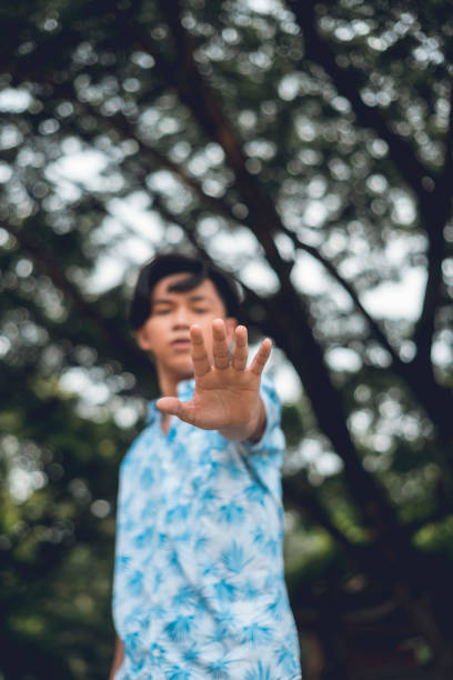 istock A man refuses to talk, putting his hand out to create distance. Focus on palm. 1407831537