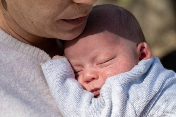 istock mother holding her baby with milia acne problem on face 1407831546