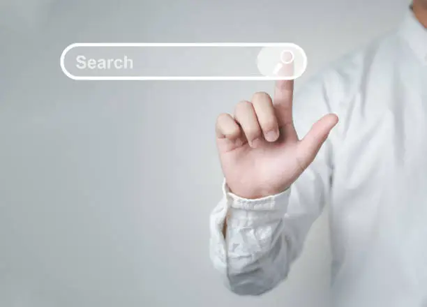 Photo of Man standing with hands pointing to information search is a data clicking to virtual internet search page computer touch screen
