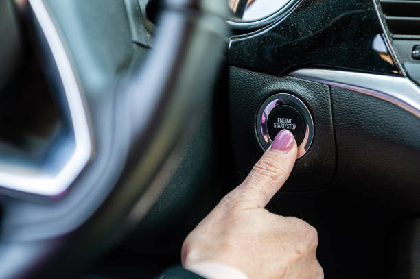 istock Woman hand pushing on car engine start-stop button. Modern car interior, closeup 1407834567