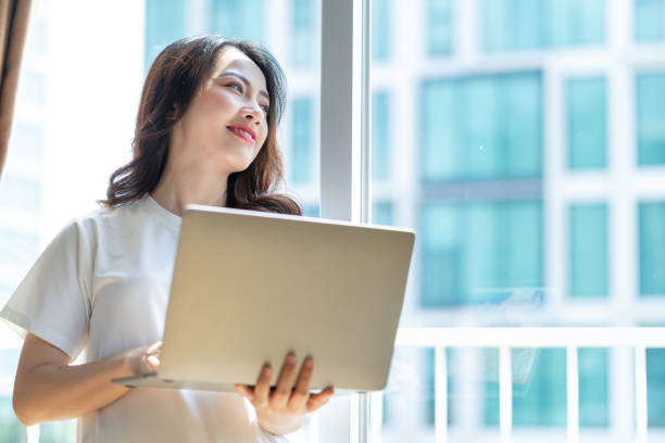 istock Young Asian woman working at home 1407834592