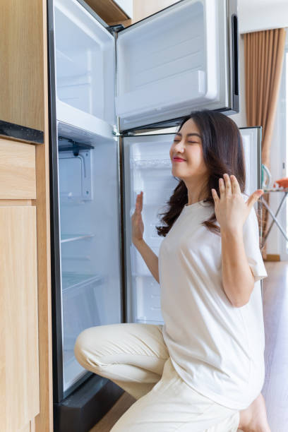 istock Image of young Asian woman with fridge 1407834643