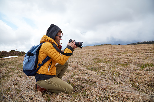 Young woman photographer enjoying in nature.