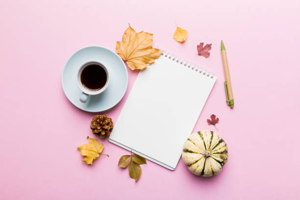 istock Autumn composition: fallen leaves and craft sketchbook mock up on colored background. Top view. Flat lay with copy space 1407835651