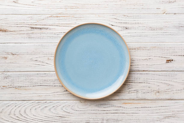 istock Top view of empty blue plate on wooden background. Empty space for your design 1407835670