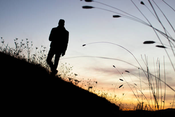 istock man's silhouette in an colorful evening sky 1407837049