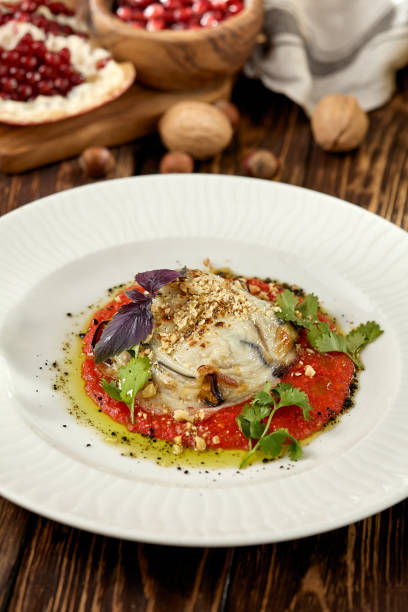 istock Hot appetizer - baked eggplant with cheese and tomatoes. Stuffed eggplants with mozzarella cheese and tomato sauce in rustic style. Eggplant and cheese appetizer on white plate in italian style. 1407837360